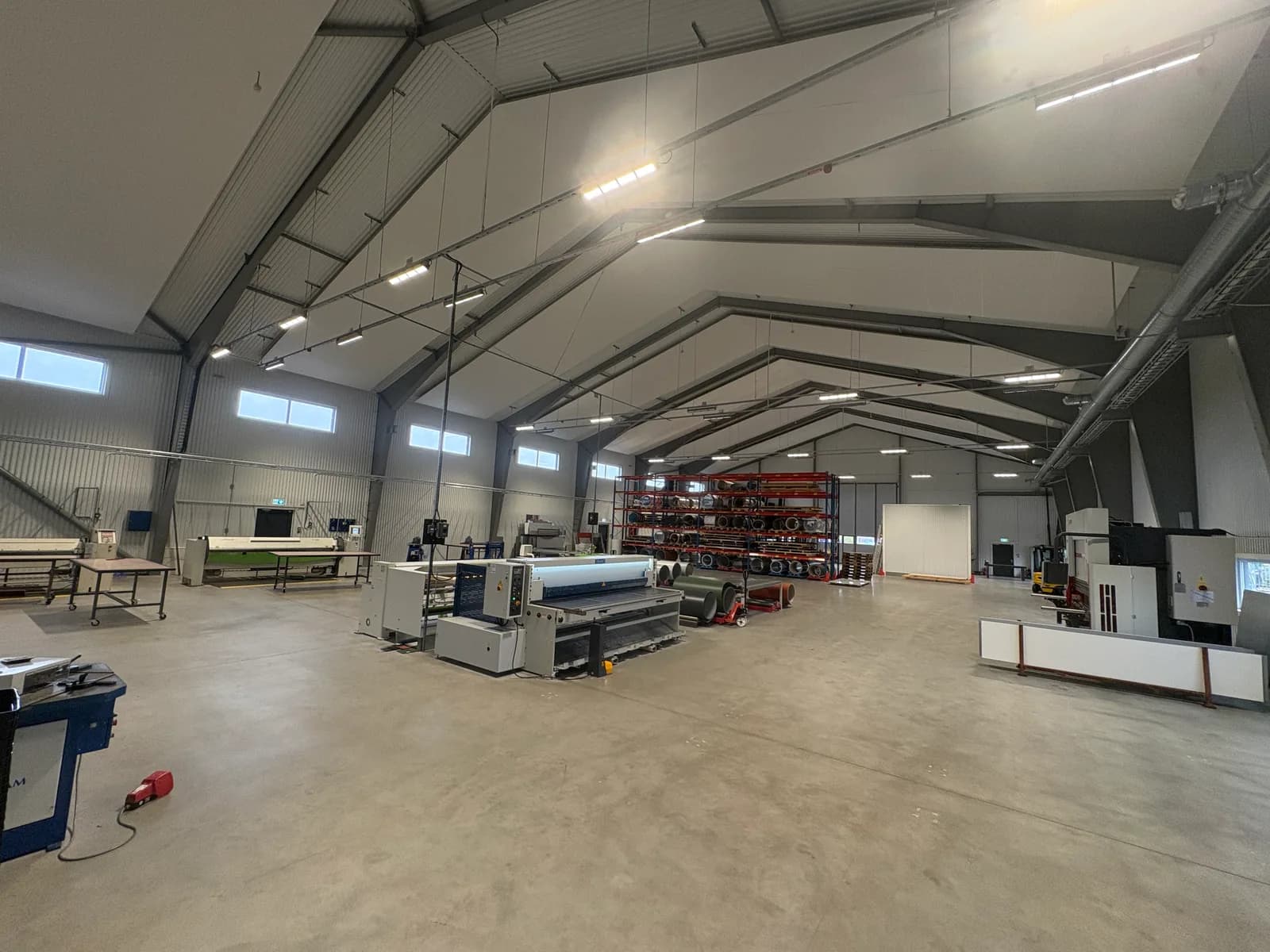 Ljus industrihall i Ekeby med maskiner och materialställage